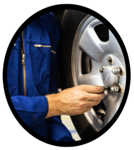 An auto mechanic rotating a set of tires