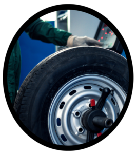 An automobile mechanic mounting a tire to a wheel rim