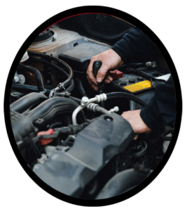 A mechanic running an air conditioning test on an automobile engine