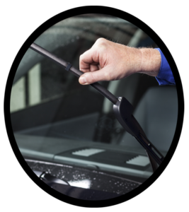 An auto mechanic inspecting a cars wiper blades