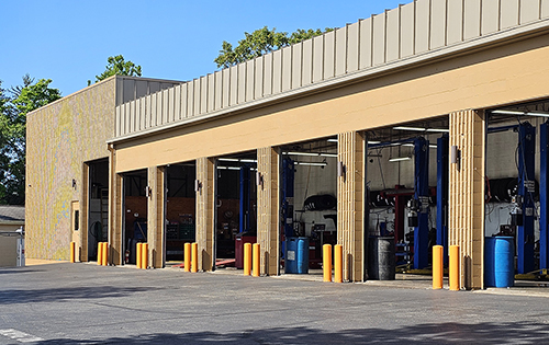 The front of an auto repair shop with all of the work bays open