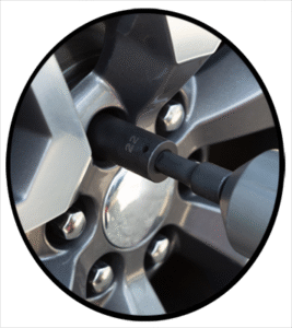 An automobile mechanic tightening the lug nuts on an installed new tire