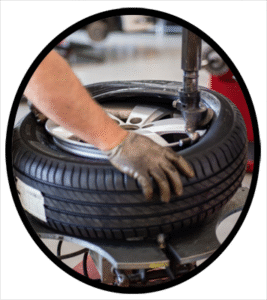 An automobile mechanic placing a new tire on a rim
