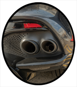 The back end of an automobile focused on the exhaust tail pipes