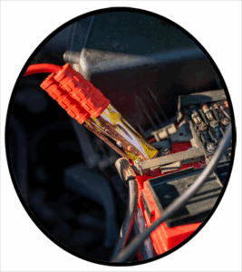 An automobile battery with jumper cables attached
