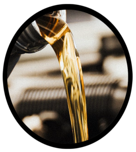 An automobile mechanic pouring engine oil during service