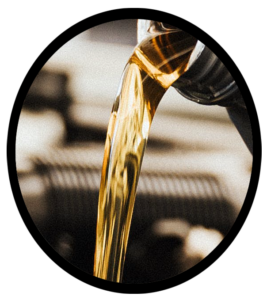 An automobile mechanic pouring oil into an engine